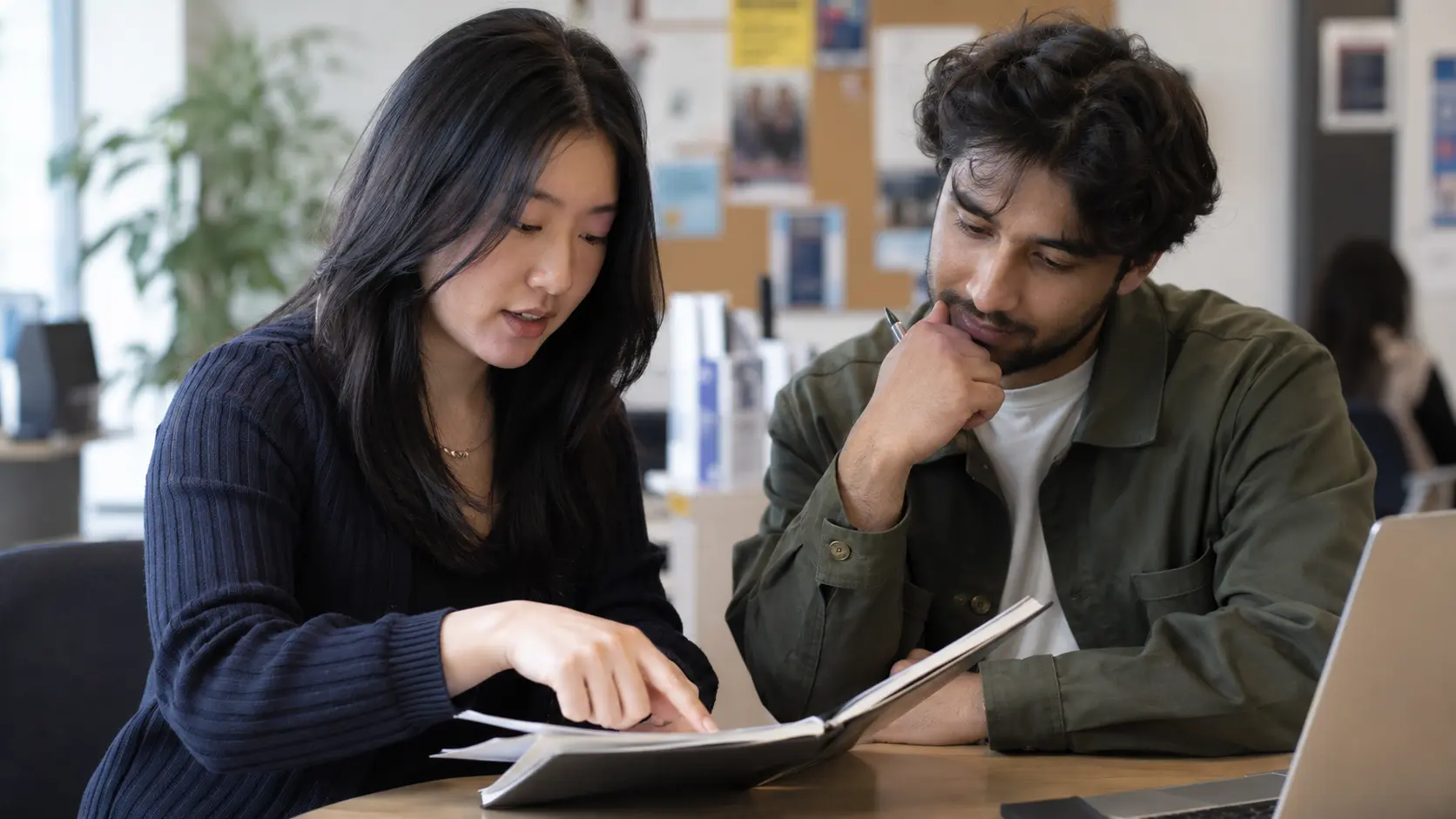 Illustrative photo of two university students reviewing a CV notebook together.